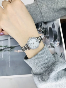Detail of silver ladies' watch featuring a diamond-set bezel and elegant metal strap