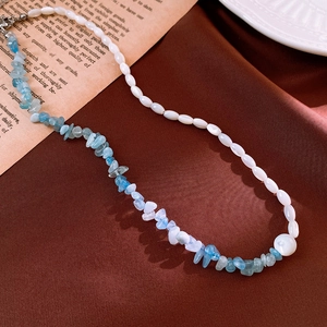 Detailed close-up of beaded necklace with aquamarine chips and elegant white pearls