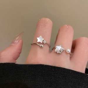 Close-up of zircon star and pearl adjustable open rings on model's hand