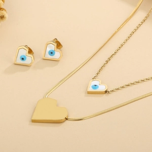 Detail view of a gold double-layer necklace and matching evil eye earrings set