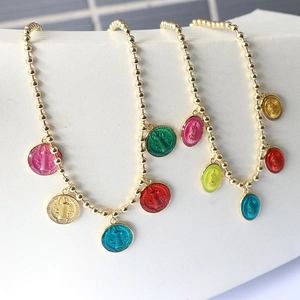 Detailed macro view of religious enamel pendants on golden bead chains for jewelry