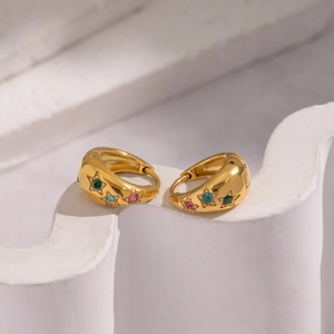 U-shaped 18K gold plated earrings with colorful zircon stars on an artistic marble stand