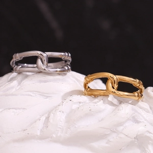 Detailed macro view of 18K gold and silver double-layered hollow rings on white stone base