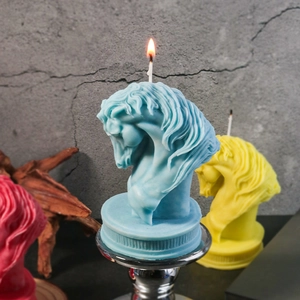Künstlerische Duftkerze in Pferdekopfform in Blau und Gelb auf einem Metallständer