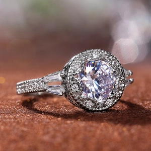 Macro side view of round halo engagement ring with baguette and pave set stones