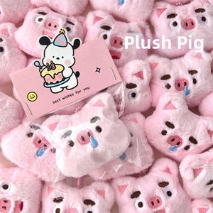 Gros plan de pendentifs tête de cochon en peluche rose avec expressions brodées