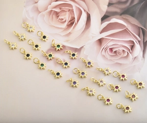 Macro view of gold star pendants with colorful cubic zirconia for jewelry making