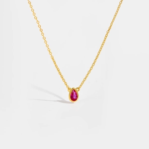 Detailed close-up of a S925 sterling silver gold chain with a red teardrop gemstone