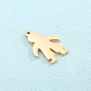 Polished titanium steel boy and girl pendants on a textured light blue surface