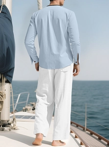 Men's linen vacation set featuring light blue shirt and white pants on a yacht