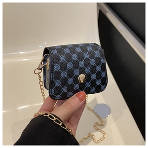 Close-up of mini blue and black chain bag featuring a clover pattern and golden buckle