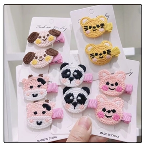 Close-up of cute knitted animal head hair clips for kids on colorful metal pins