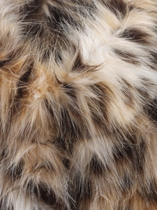 Close-up of premium leopard print faux fur texture showing soft plush material fibers