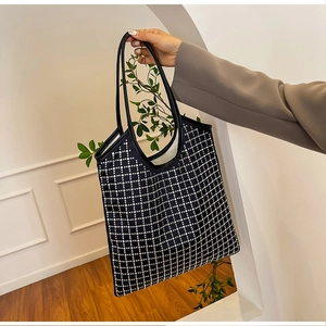 Macro detail of high-capacity black rhinestone tote bag with sparkling checkerboard pattern