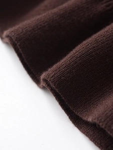 Detaillierte Makroansicht der weichen braunen Strickbündchen und der feinen Textur am Stoff