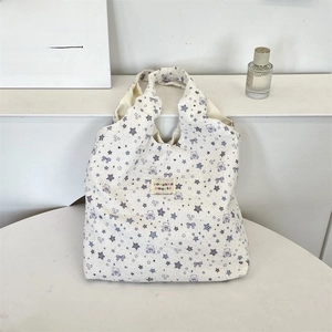 Detailed close-up of floral tote bag showing purple bear patterns and waffle fabric texture
