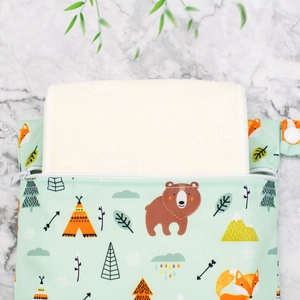 Detail of mint green waterproof diaper bag with forest animal print and zipper closure