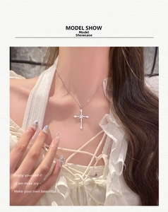 Detailed view of a silver star-cross pendant necklace with sparkling white zircon crystals