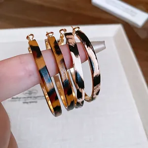 Classic leopard print hoop earrings in brown and grey tones with elegant gold hardware
