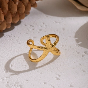 Macro di anello a stella marina in oro 18K con texture realistica su sfondo di pietra bianca