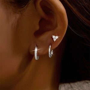 Close-up of S925 silver earring set with paved zirconia hoops and a heart stud