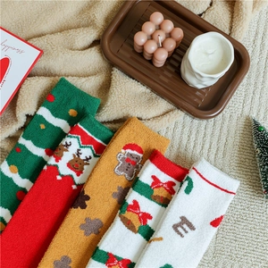 Close-up of festive Christmas coral fleece socks with reindeer and tree patterns