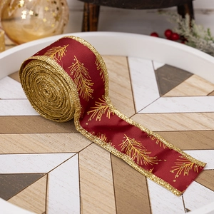 Detailed view of red Christmas ribbon with gold pine patterns and glitter edges on a tray