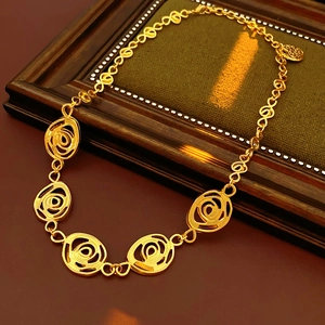 Detail of vintage gold swirl necklace on a rustic wooden frame with O-link chain