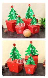 Christmas gift box with red deer silhouette and 3D green tree topper on wooden table
