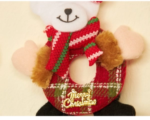 Detail of Christmas plush bear ornament with festive plaid ring and Merry Christmas tag
