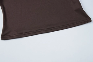 Détail de l'ourlet à double couture sur un t-shirt marron foncé à coupe ajustée