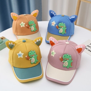 Flat lay of colorful baby baseball caps with 3D dinosaur ears and embroidery details