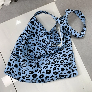 Top-down view of a spacious blue leopard print corduroy tote bag on a flat floor