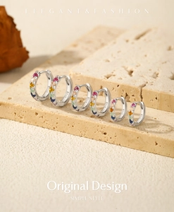 Macro view of six S925 sterling silver hoop earrings with colorful rainbow zircons