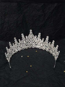 Macro shot of silver hollow-out crown hairband with rhinestones on black paper