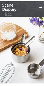 Detailed view of stainless steel measuring cups with flour and baking tools on a wooden board