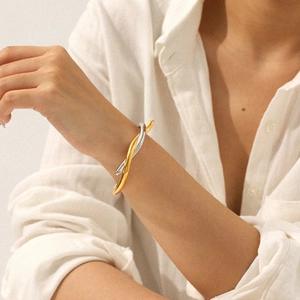 Two-tone intertwined stainless steel knot bangle bracelet for women on model wrist