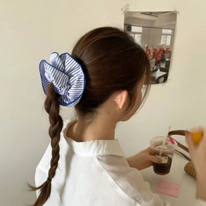 Blue and white striped fabric scrunchie shown on a ponytail for a stylish look