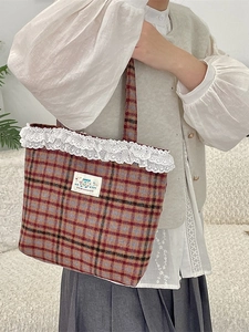 Plaid canvas tote bag with white lace trim and happy cartoon patch shown on model