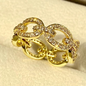 Macro shot of gold curb link ring featuring micro-pave white crystals and modern design