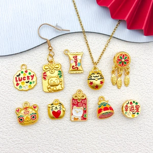 Golden lucky cat enamel charms set for DIY jewelry making on a textured white background