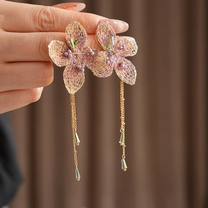 Detailed shot of vintage knitted flower earrings with tassels and purple beads