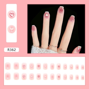 Pink blush gradient press-on nails with white French tips and red heart patterns