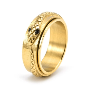 Golden stainless steel snake spinner ring with black gemstone eyes on white background