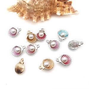 Detail view of pearl seashell alloy charms in gold, silver, and colorful enamel finishes