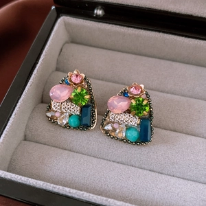 Vue détaillée de boucles d'oreilles vintage avec cristaux roses sur velours gris
