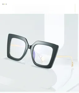 Detail of square black glasses with gold metal temples and white pearl accents