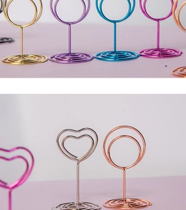 Close-up of colorful metal wire memo holders in heart and circle shapes with spiral bases