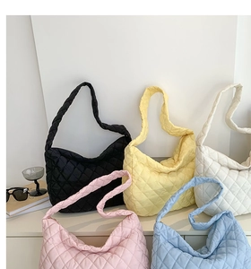 Quilted crossbody bags in black, yellow, white, pink and blue on a white display