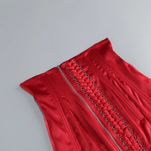 Détails du corset en satin rouge avec œillets métalliques et fermeture à lacets